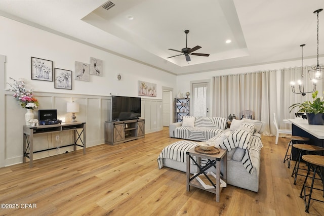 3928 Sandpine Way, Panama City, FL 32404 - living room with a tray ceiling, a ceiling fan, a chandelier, light wood-style floors, and recessed lighting