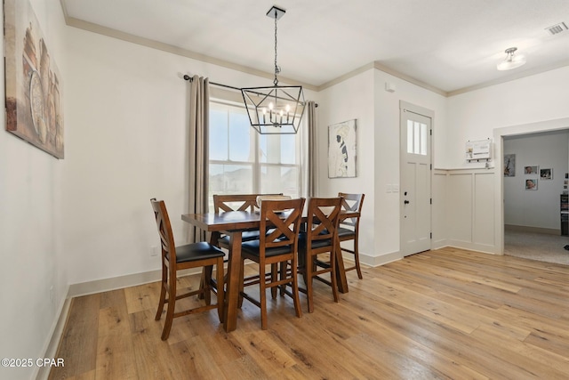 3928 Sandpine Way, Panama City, FL 32404 - dining area featuring light wood-style flooring, a chandelier, baseboards, and crown molding