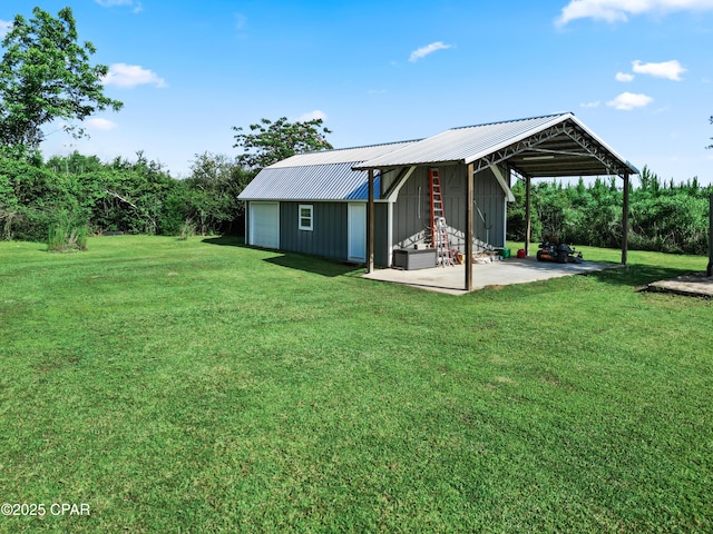 18562 Lois Fowler Rd, Blountstown, FL 32424 - back of property with a garage, an outdoor structure, a lawn, and board and batten siding