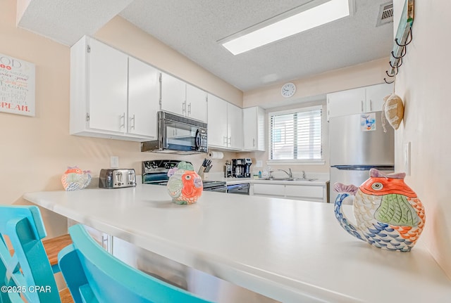 17620 Front Beach Rd Unit 2V, Panama City Beach, FL 32413 - kitchen featuring black microwave, freestanding refrigerator, electric range oven, a textured ceiling, and a sink