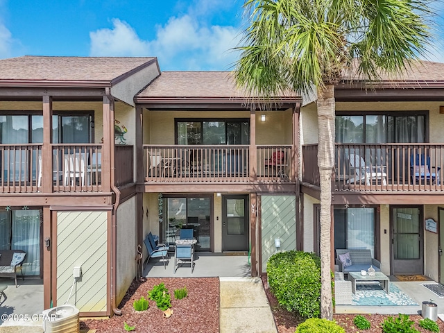 17620 Front Beach Rd Unit 2V, Panama City Beach, FL 32413 - back of house with stucco siding, roof with shingles, and a patio area