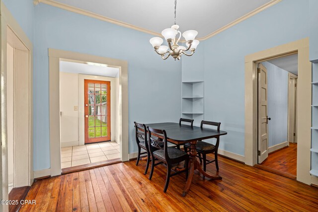 208 N E Ave, Panama City, FL 32401 - dining area featuring hardwood / wood-style flooring, ornamental molding, a chandelier, and baseboards