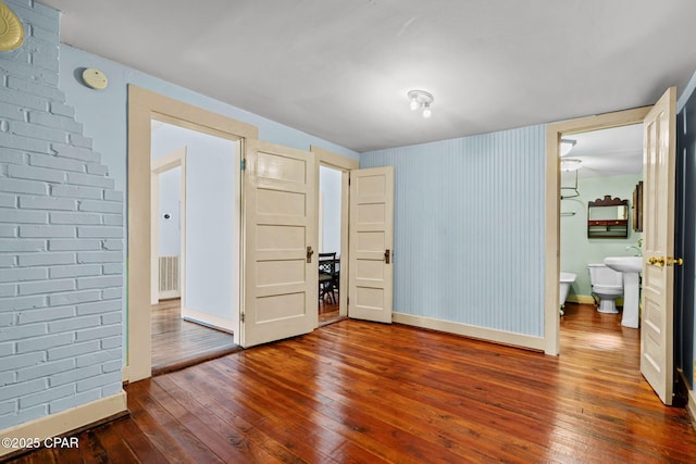 208 N E Ave, Panama City, FL 32401 - unfurnished bedroom featuring dark wood-style floors, baseboards, and connected bathroom