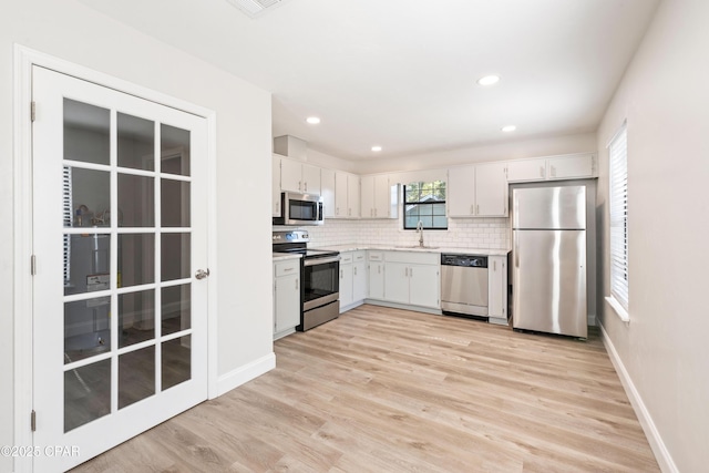 4130 White Pine Ct, Tallahassee, FL 32311 - kitchen with stainless steel appliances, a sink, light countertops, backsplash, and light wood-style flooring