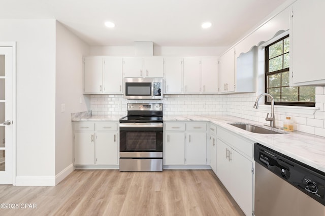 4130 White Pine Ct, Tallahassee, FL 32311 - kitchen featuring stainless steel appliances, a sink, light wood finished floors, tasteful backsplash, and recessed lighting