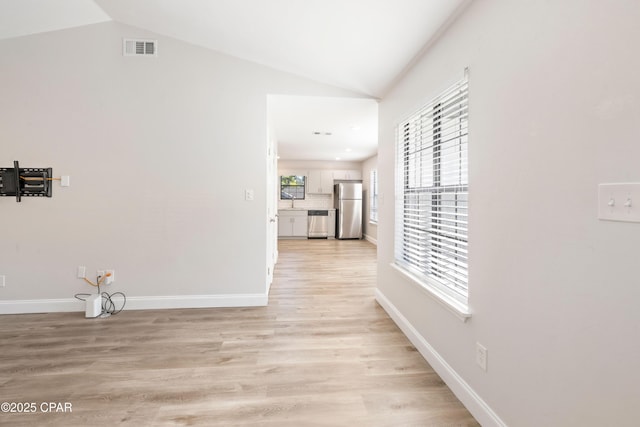 4130 White Pine Ct, Tallahassee, FL 32311 - hallway with vaulted ceiling, light wood-style flooring, and baseboards