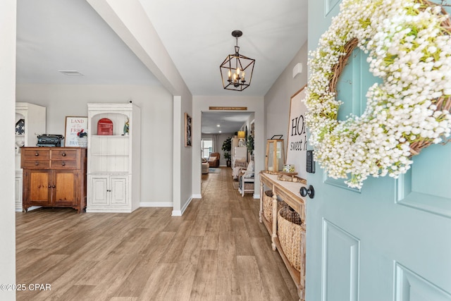 160 James Way, Southport, FL 32409 - foyer entrance with light wood finished floors, a chandelier, and baseboards