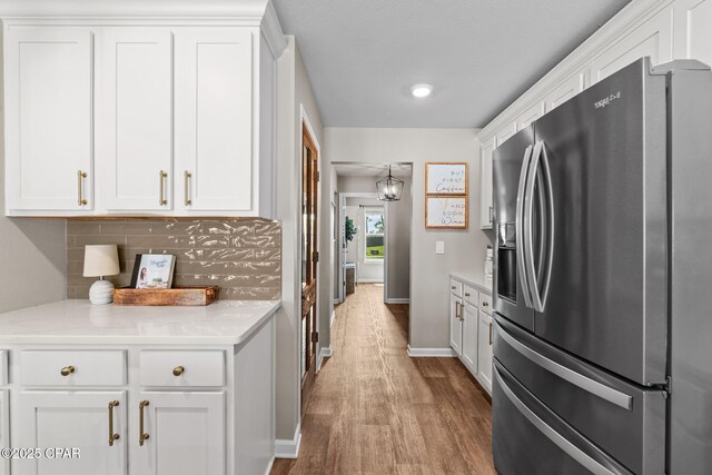 160 James Way, Southport, FL 32409 - kitchen with stainless steel fridge with ice dispenser, wood finished floors, and white cabinets