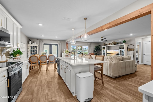 160 James Way, Southport, FL 32409 - kitchen featuring appliances with stainless steel finishes, a sink, a breakfast bar, light wood-style floors, and recessed lighting