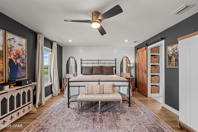 160 James Way, Southport, FL 32409 - bedroom featuring wood finished floors, a barn door, baseboards, ceiling fan, and recessed lighting