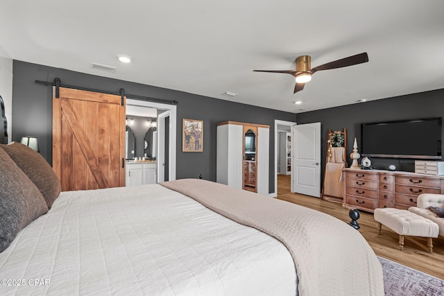 160 James Way, Southport, FL 32409 - bedroom featuring wood finished floors, a barn door, ceiling fan, recessed lighting, and ensuite bath