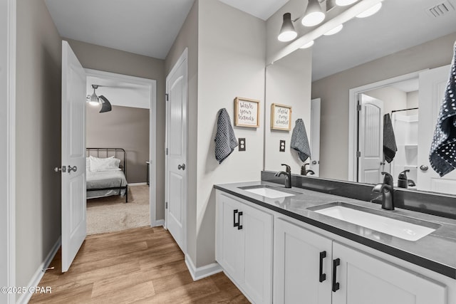 160 James Way, Southport, FL 32409 - ensuite bathroom featuring wood finished floors, double vanity, and baseboards