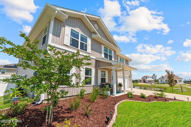 160 James Way, Southport, FL 32409 - view of front of house with a garage, concrete driveway, board and batten siding, and a front lawn