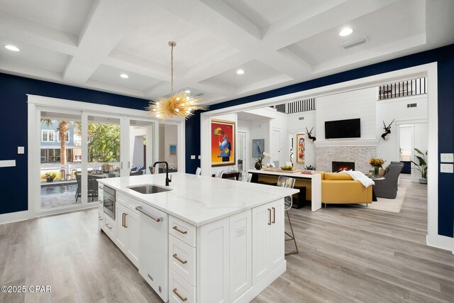 135 Buddy St, Santa Rosa Beach, FL 32459 - kitchen featuring a sink, dishwasher, an island with sink, coffered ceiling, and a lit fireplace