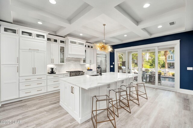 135 Buddy St, Santa Rosa Beach, FL 32459 - kitchen featuring a spacious island, backsplash, white cabinetry, a breakfast bar, and light stone counters