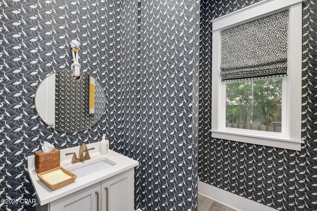 135 Buddy St, Santa Rosa Beach, FL 32459 - bathroom with wallpapered walls, wood finished floors, and vanity