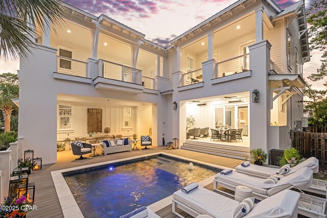 135 Buddy St, Santa Rosa Beach, FL 32459 - back of property featuring an outdoor living space, a balcony, an outdoor pool, outdoor dining area, and stucco siding