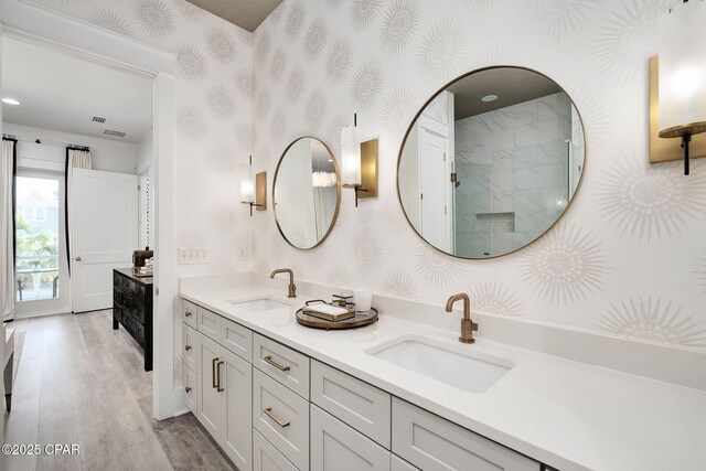135 Buddy St, Santa Rosa Beach, FL 32459 - full bathroom with wallpapered walls, wood finished floors, a shower with shower door, and double vanity