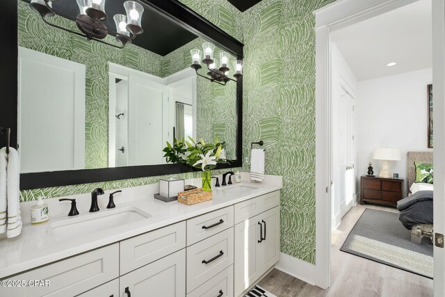 135 Buddy St, Santa Rosa Beach, FL 32459 - full bathroom featuring wallpapered walls, a chandelier, wood finished floors, double vanity, and baseboards