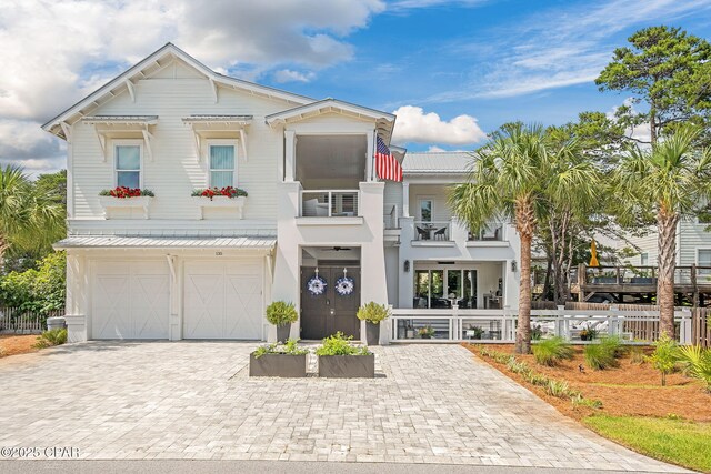 135 Buddy St, Santa Rosa Beach, FL 32459 - view of front facade featuring a balcony, metal roof, driveway, a garage, and stucco siding