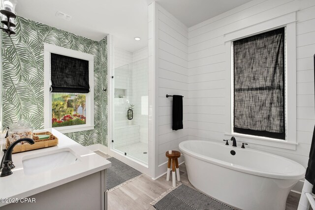 135 Buddy St, Santa Rosa Beach, FL 32459 - full bath with wood finished floors, a shower stall, wallpapered walls, a freestanding bath, and vanity