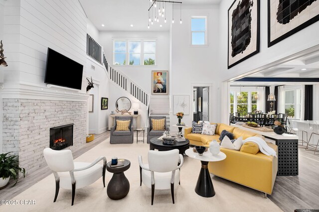 135 Buddy St, Santa Rosa Beach, FL 32459 - living room featuring wood finished floors, a brick fireplace, a high ceiling, stairway, and recessed lighting