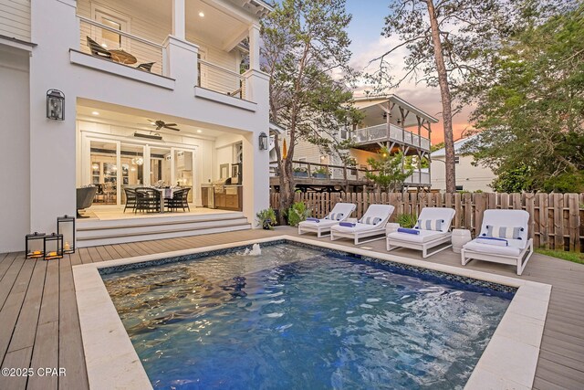 135 Buddy St, Santa Rosa Beach, FL 32459 - pool at dusk featuring a deck, outdoor dining area, and a ceiling fan