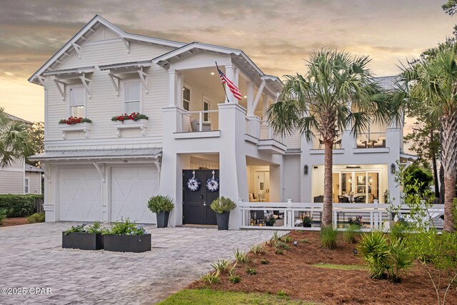 135 Buddy St, Santa Rosa Beach, FL 32459 - view of front of house featuring a balcony, decorative driveway, and an attached garage