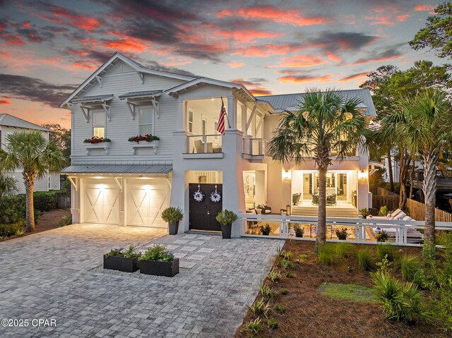 135 Buddy St, Santa Rosa Beach, FL 32459 - view of front of home with a balcony, an attached garage, decorative driveway, metal roof, and stucco siding