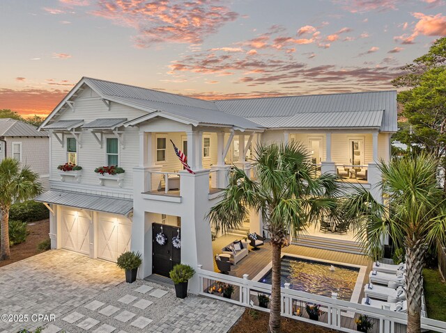 135 Buddy St, Santa Rosa Beach, FL 32459 - view of front of property with a balcony, metal roof, decorative driveway, and a garage