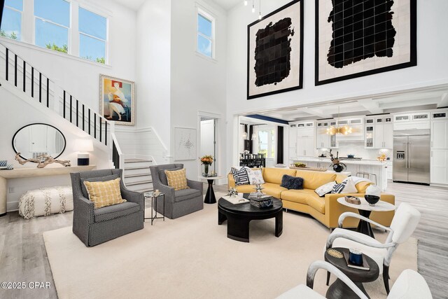 135 Buddy St, Santa Rosa Beach, FL 32459 - living area featuring light wood-style floors, stairs, a towering ceiling, beamed ceiling, and baseboards