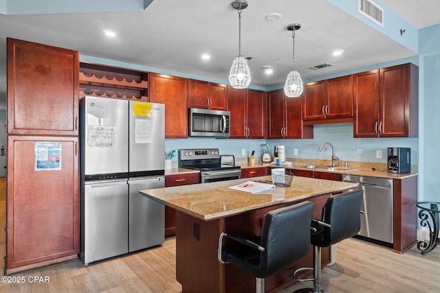 9902 S Thomas Dr Unit 135, Panama City Beach, FL 32408 - kitchen featuring stainless steel appliances, a sink, light wood-style floors, light stone countertops, and recessed lighting