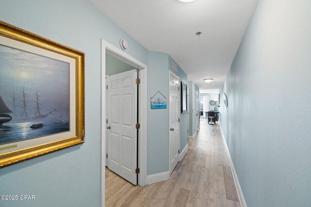 9902 S Thomas Dr Unit 135, Panama City Beach, FL 32408 - corridor with baseboards and light wood-style flooring