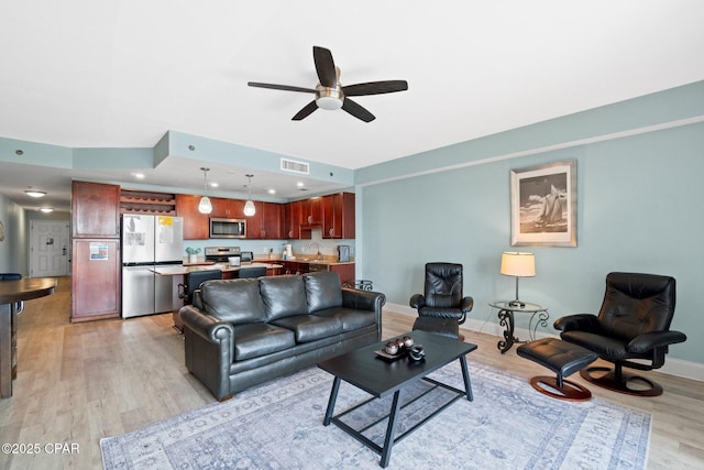 9902 S Thomas Dr Unit 135, Panama City Beach, FL 32408 - living room with light wood-style floors, ceiling fan, and baseboards