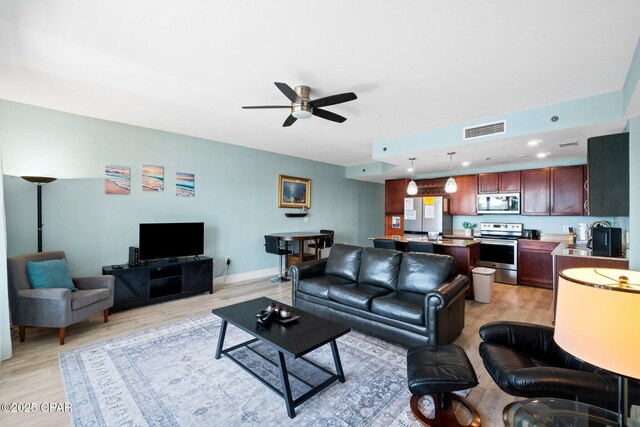 9902 S Thomas Dr Unit 135, Panama City Beach, FL 32408 - living room featuring light wood-style floors, ceiling fan, and baseboards