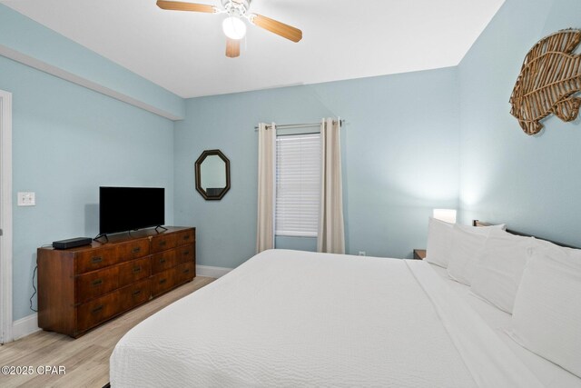 9902 S Thomas Dr Unit 135, Panama City Beach, FL 32408 - bedroom featuring baseboards, light wood-style flooring, and ceiling fan