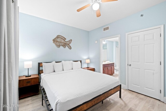 9902 S Thomas Dr Unit 135, Panama City Beach, FL 32408 - bedroom with light wood finished floors, ensuite bathroom, and ceiling fan