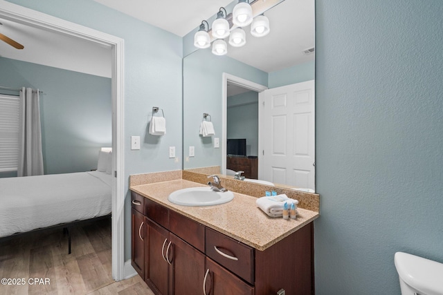 9902 S Thomas Dr Unit 135, Panama City Beach, FL 32408 - ensuite bathroom with wood finished floors, vanity, toilet, and a ceiling fan