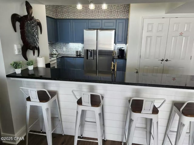 14701 Front Beach Rd Unit 1727, Panama City Beach, FL 32413 - kitchen featuring stainless steel refrigerator with ice dispenser, blue cabinetry, dark countertops, decorative backsplash, and a peninsula
