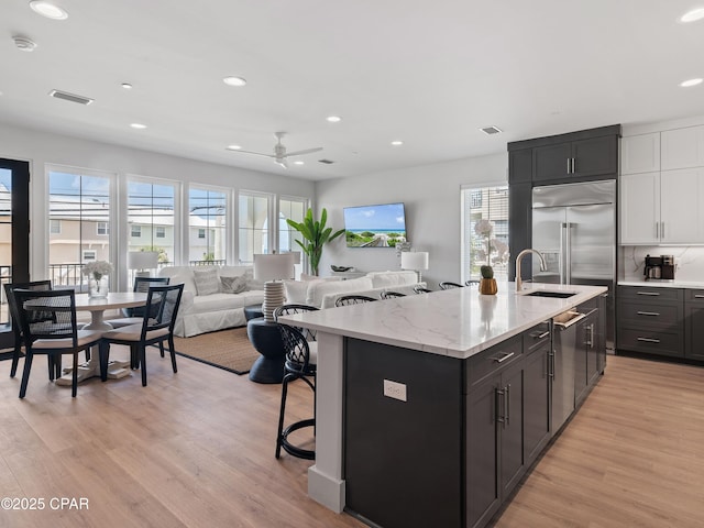 101 Deluna Pl Unit C, Panama City Beach, FL 32413 - kitchen featuring plenty of natural light, light wood-type flooring, recessed lighting, a kitchen bar, and a sink