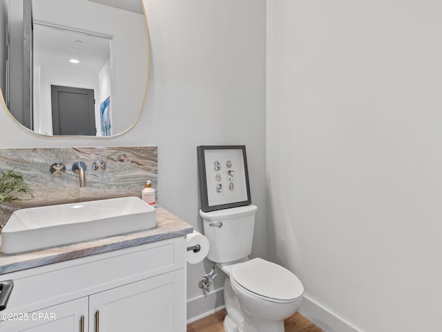 101 Deluna Pl Unit C, Panama City Beach, FL 32413 - bathroom featuring baseboards, toilet, wood finished floors, and vanity