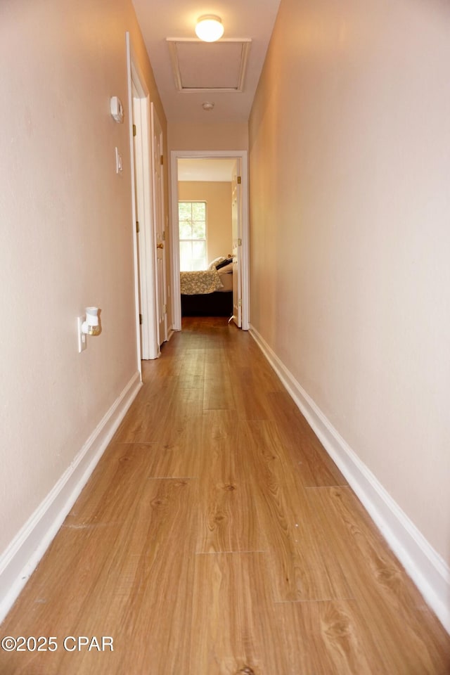 2738 W Tharpe St Unit 1103, Tallahassee, FL 32303 - hallway featuring light wood-type flooring, baseboards, and attic access