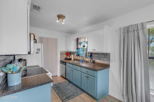 4331 Garrison Rd, Panama City, FL 32404 - kitchen with stainless steel dishwasher, blue cabinetry, white cabinetry, light wood-style flooring, and dark countertops