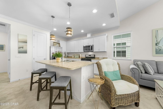 8636 Conch Shell Ct, Panama City Beach, FL 32413 - kitchen featuring stainless steel appliances, a breakfast bar, white cabinetry, recessed lighting, and open floor plan