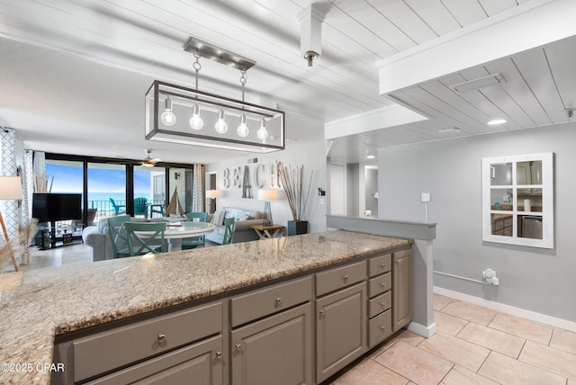 6201 Thomas Dr Unit 202, Panama City Beach, FL 32408 - kitchen with gray cabinets, open floor plan, light tile patterned floors, baseboards, and decorative light fixtures
