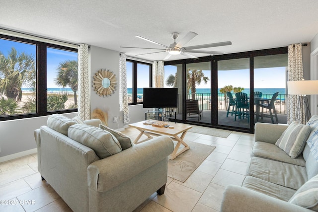 6201 Thomas Dr Unit 202, Panama City Beach, FL 32408 - living area with a ceiling fan, light tile patterned floors, a textured ceiling, and baseboards