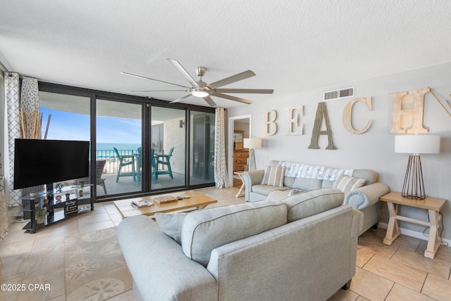 6201 Thomas Dr Unit 202, Panama City Beach, FL 32408 - living room with a textured ceiling, ceiling fan, tile patterned floors, and baseboards