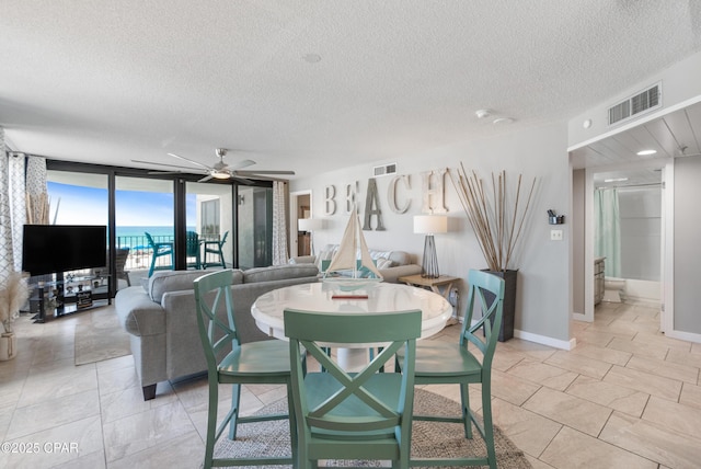 6201 Thomas Dr Unit 202, Panama City Beach, FL 32408 - dining room with a textured ceiling, a ceiling fan, expansive windows, and baseboards