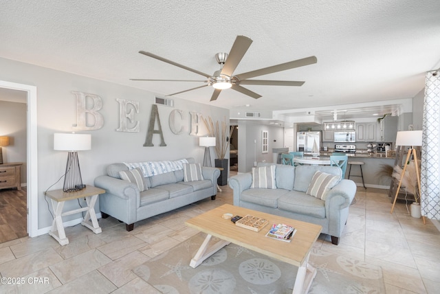6201 Thomas Dr Unit 202, Panama City Beach, FL 32408 - living room with a ceiling fan, a textured ceiling, and baseboards