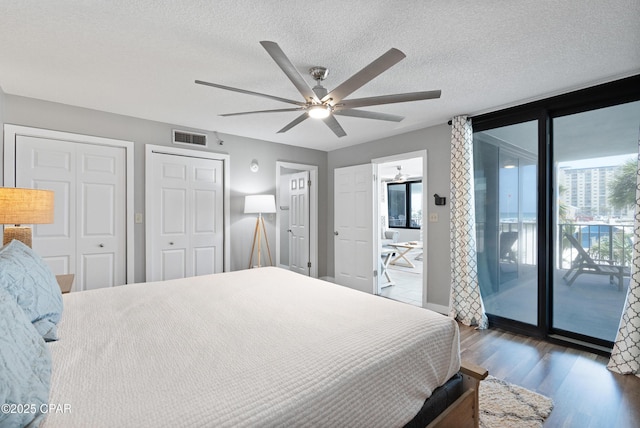 6201 Thomas Dr Unit 202, Panama City Beach, FL 32408 - bedroom with access to exterior, wood finished floors, a textured ceiling, a ceiling fan, and multiple closets